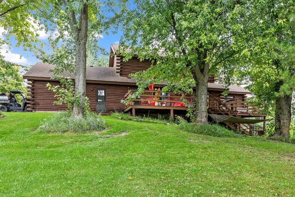 a front view of a house with garden and trees