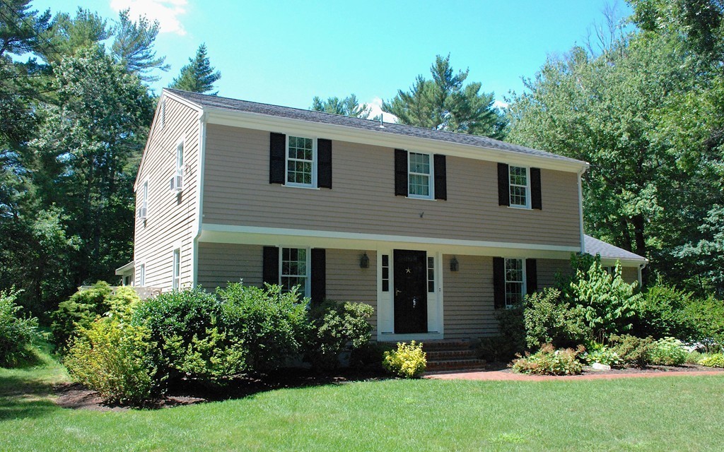 a front view of a house with a garden and plants