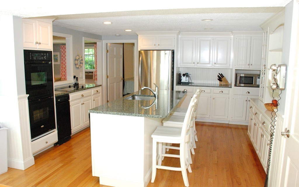 76 Stagecoach Road Duxbury, MA 02332 - Photo 7 of 26 a kitchen with stainless steel appliances granite countertop a refrigerator a stove top oven and a sink with wooden floor