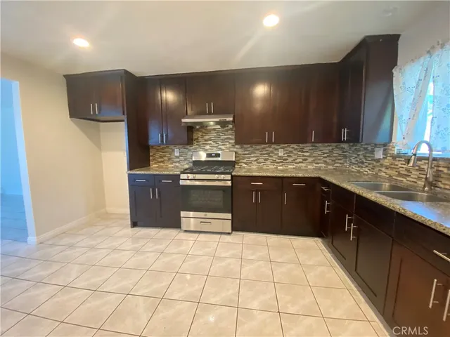 a kitchen with stainless steel appliances granite countertop a sink and a stove