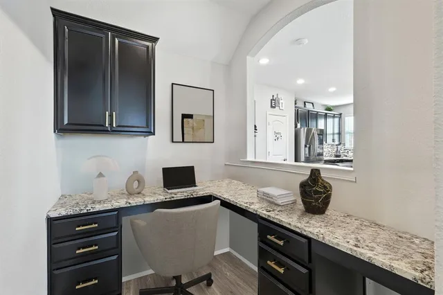 a kitchen with granite countertop a sink cabinets and wooden floor