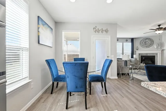 a dining room with furniture a fireplace and wooden floor