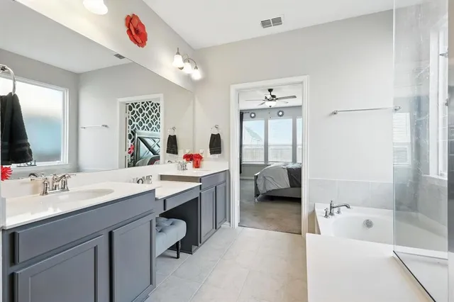 a en suite bathroom with a tub sink a mirror and a shower