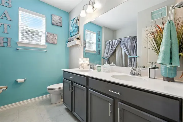 a bathroom with a granite countertop toilet sink and mirror