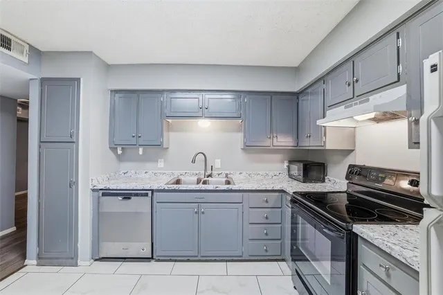 a kitchen with a sink stove and cabinets