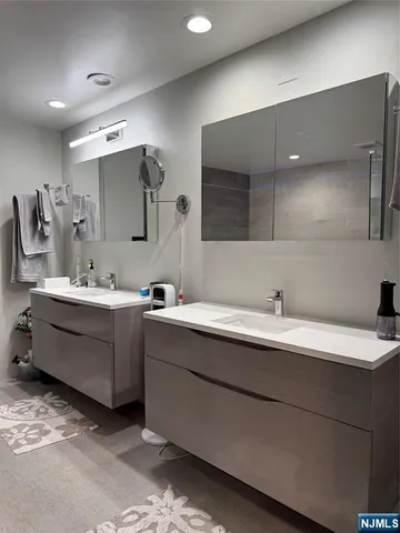 a bathroom with a double vanity sink toilet and a mirror