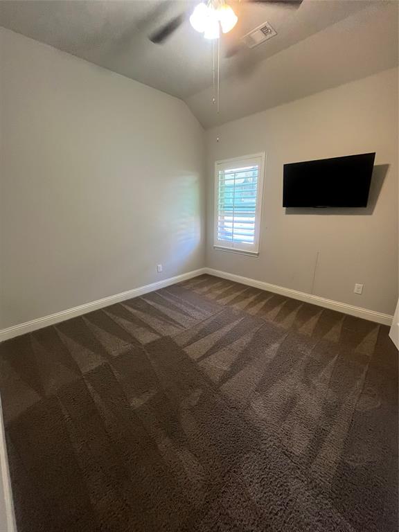 7040 Cross Point Lane Little Elm, TX 76227 - Photo 11 of 16 an empty room with a flat screen tv and kitchen view