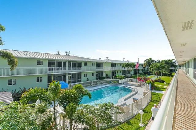 a view of a house with backyard sitting area and swimming pool