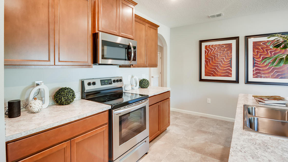 3309 Trinity Circle Fort Pierce, FL 34945 - Photo 3 of 19 a kitchen with stainless steel appliances granite countertop a stove a sink and a microwave