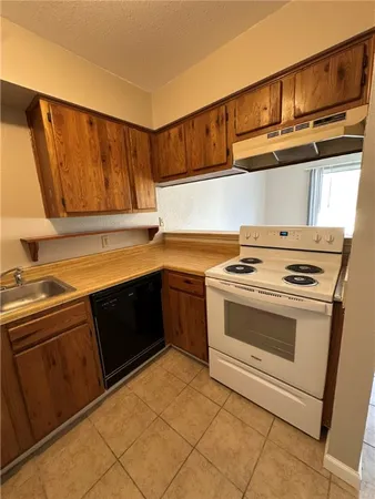 a view of a kitchen with a sink and a refrigerator