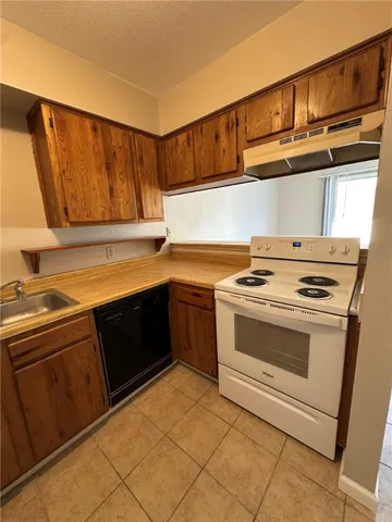 a view of a kitchen with a sink and a refrigerator