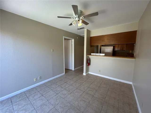 an empty room with a window and ceiling fan