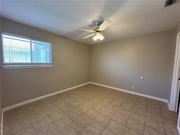 an empty room with closet and a ceiling fan