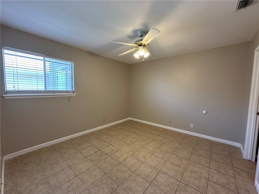 4917 Delwood Street, Unit C3 Corpus Christi, TX 78413 - Photo 16 of 24 an empty room with a window and ceiling fan