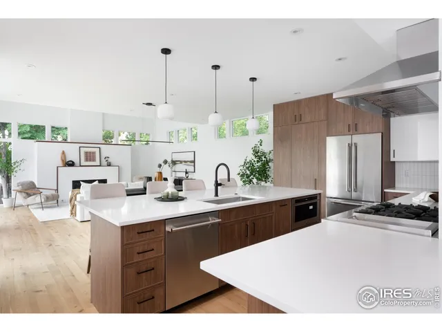 a kitchen with stainless steel appliances a sink a stove a refrigerator and cabinets