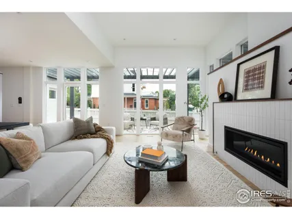a living room with furniture a fireplace and a large window
