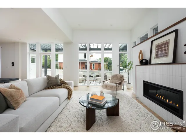 a living room with furniture a fireplace and a large window