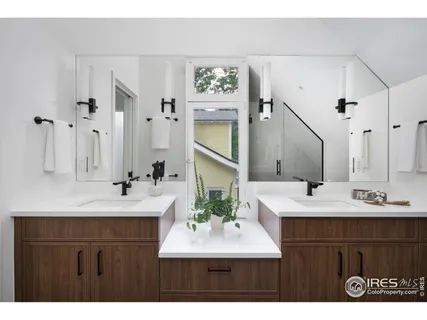 a bathroom with a sink double vanity granite tub and a mirror