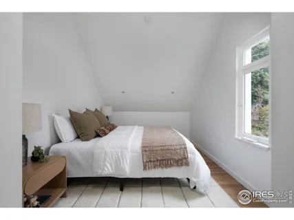 a bedroom with a bed a mirror and a window