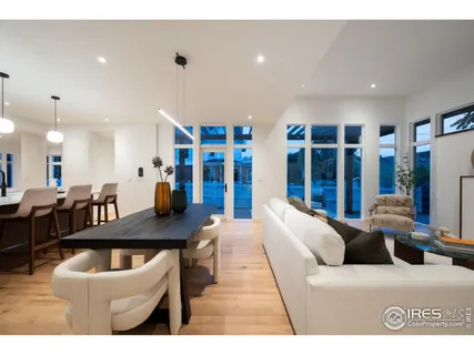 a living room with furniture a large window and kitchen view