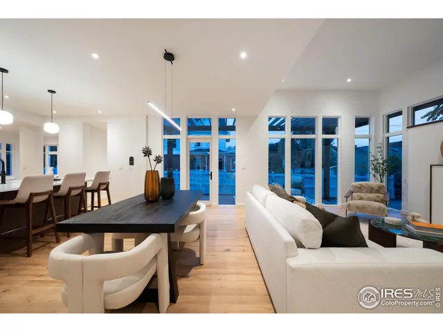a living room with furniture a large window and kitchen view