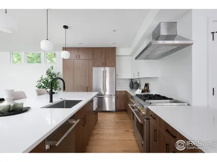 a kitchen with stainless steel appliances granite countertop a sink a stove and a refrigerator
