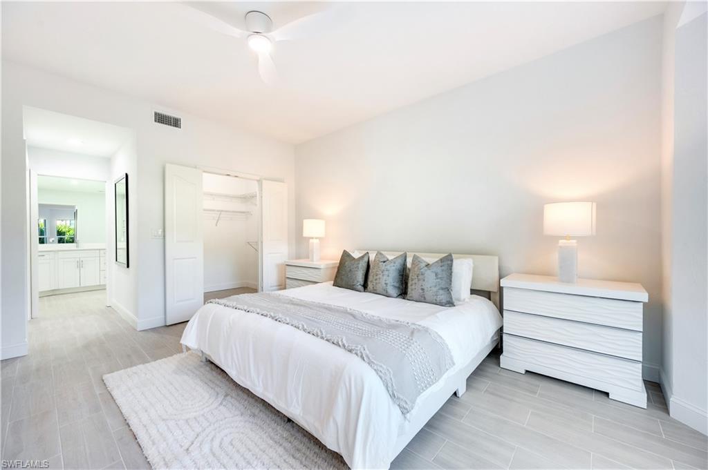2806 Aintree Lane, Unit H102 Naples, FL 34112 - Photo 14 of 26 Bedroom featuring a closet, a ceiling fan, wood finish floors, and ensuite bath