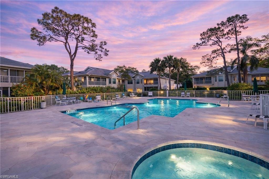 2806 Aintree Lane, Unit H102 Naples, FL 34112 - Photo 24 of 26 Pool at dusk with a patio, a community pool, a community hot tub, and a residential view