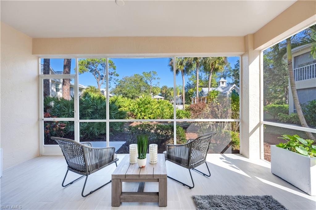 2806 Aintree Lane, Unit H102 Naples, FL 34112 - Photo 6 of 26 Sunroom / solarium with wood finished floors and a textured wall