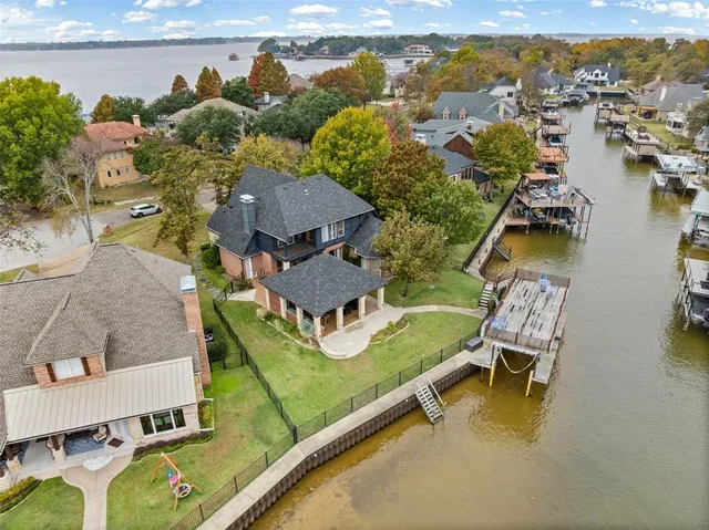 an aerial view of a house with a garden and lake view