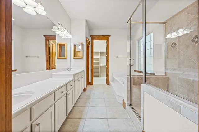 a bathroom with a double vanity sink a toilet a mirror and shower