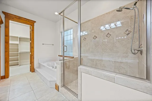 a spacious bathroom with a tub shower and mirror