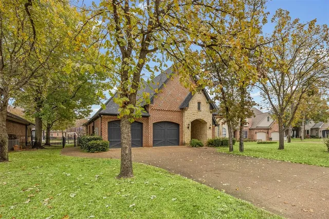 a front view of a house with a garden and tree