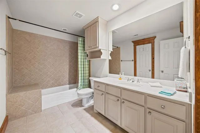 a bathroom with a double vanity sink toilet mirror and shower