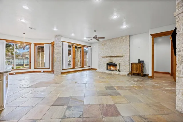 a view of an empty room with a fireplace and a window