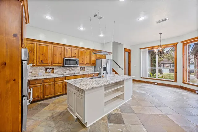 a kitchen with stainless steel appliances granite countertop a stove a sink and a refrigerator
