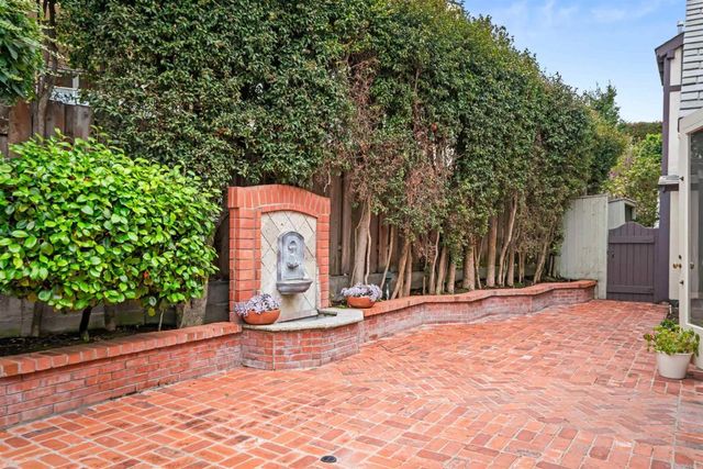 a kitchen with stainless steel appliances granite countertop a sink a stove and white cabinets