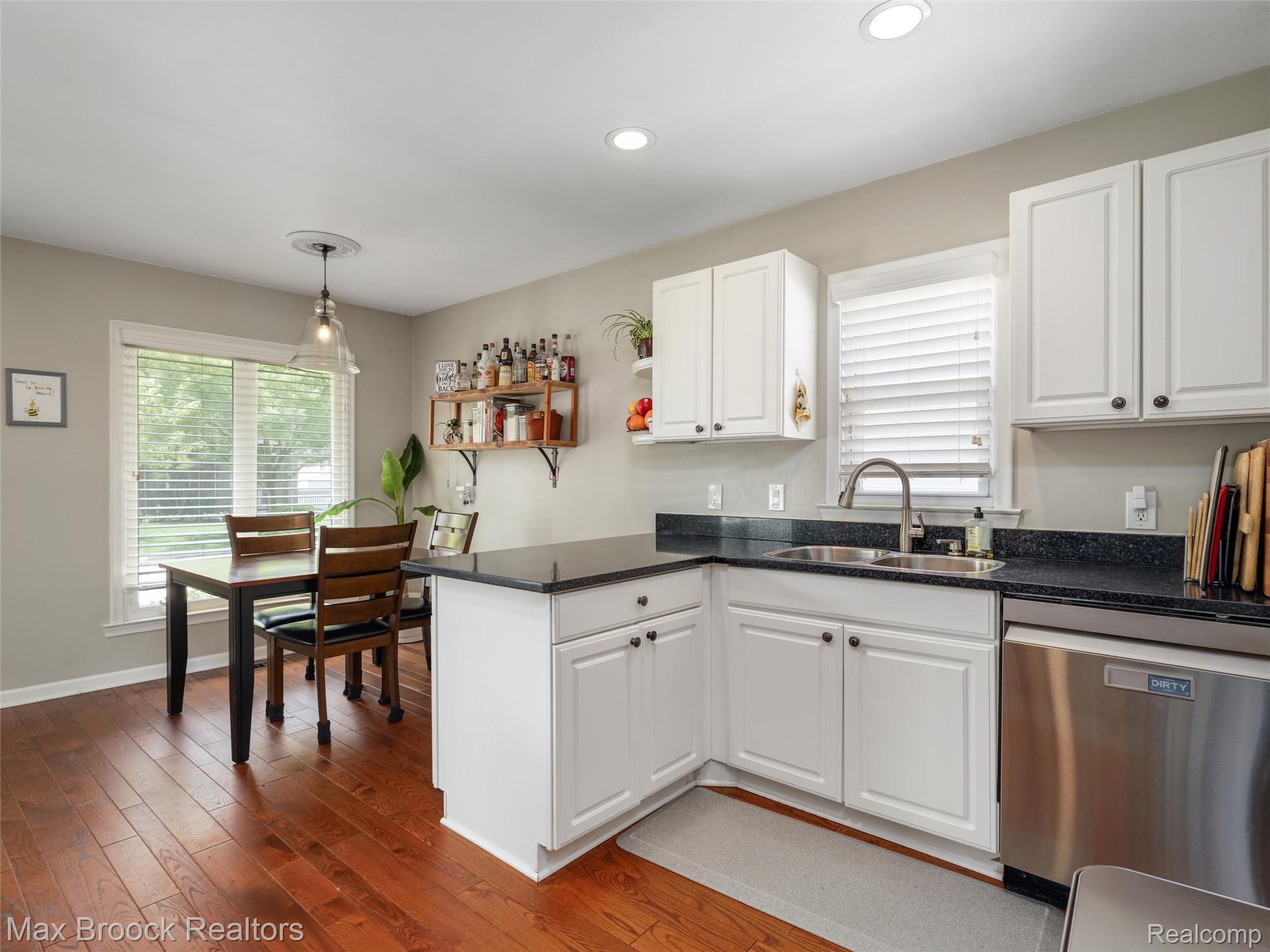 1201 Cole Street Birmingham, MI 48009 - Photo 11 of 35 Kitchen featuring white cabinetry, dark speckled countertops, stainless steel appliances, and wood-finish flooring