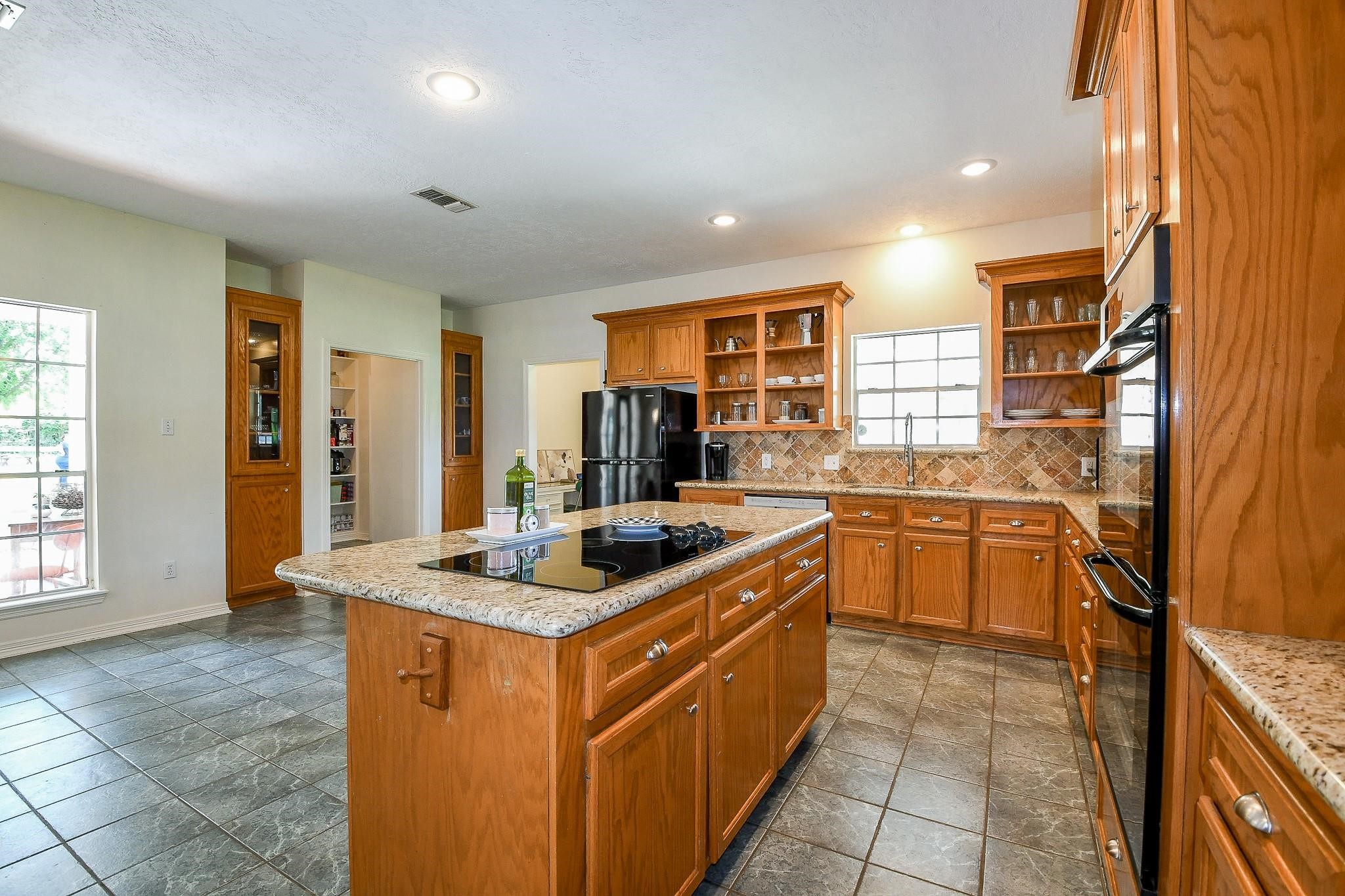22035 Buescher Road Tomball, TX 77377 - Photo 16 of 44 a kitchen with stainless steel appliances granite countertop a stove a sink and a refrigerator
