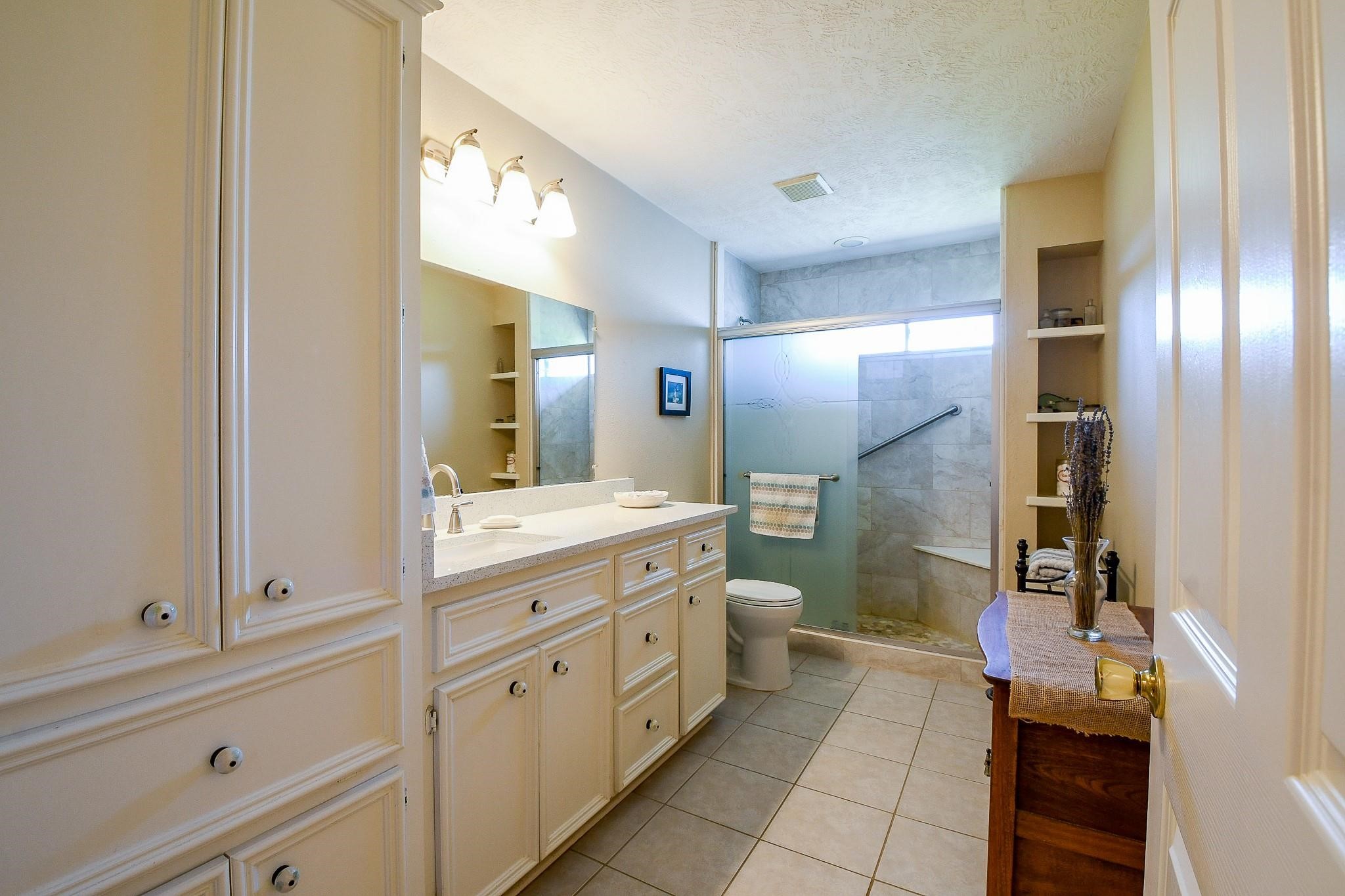 22035 Buescher Road Tomball, TX 77377 - Photo 43 of 44 a spacious bathroom with a granite countertop sink mirror and a toilet
