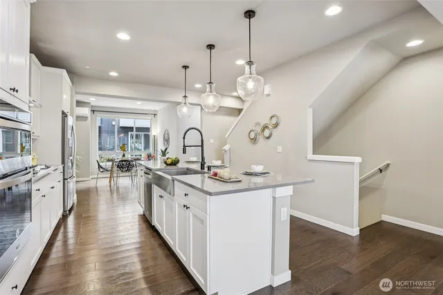 a view of a kitchen and living room with wooden floor