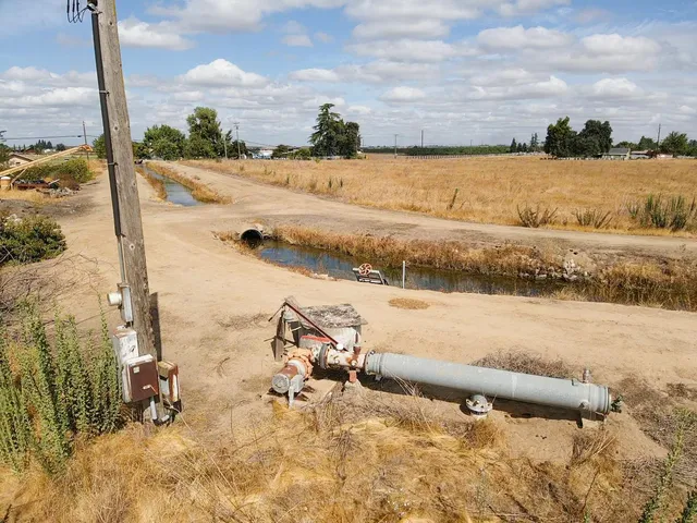 an aerial view of a house with a yard and covered with trees