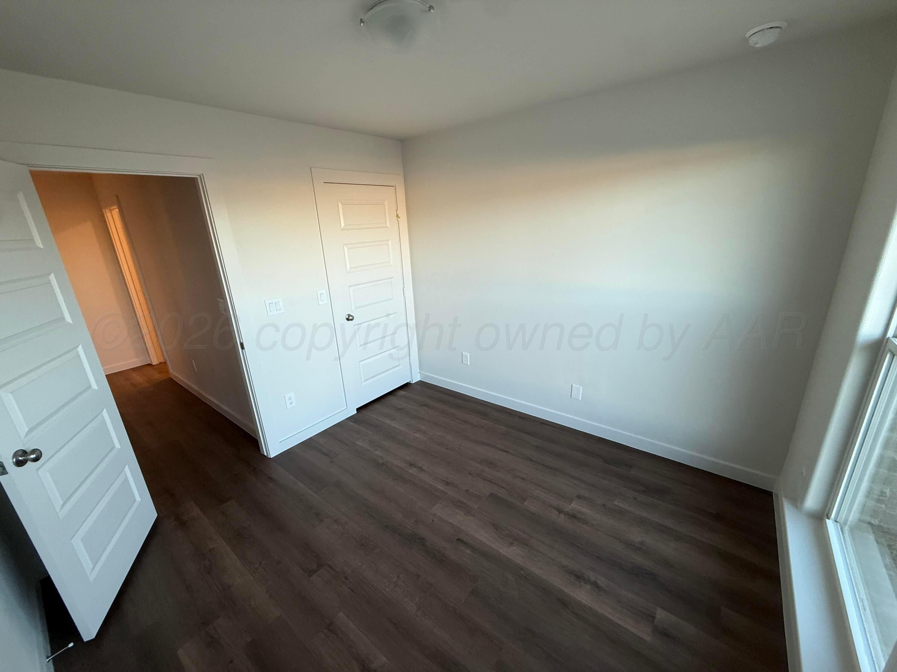 2911 Ranch House Road Amarillo, TX 79124 - Photo 12 of 18 a view of an empty room with wooden floor and a window