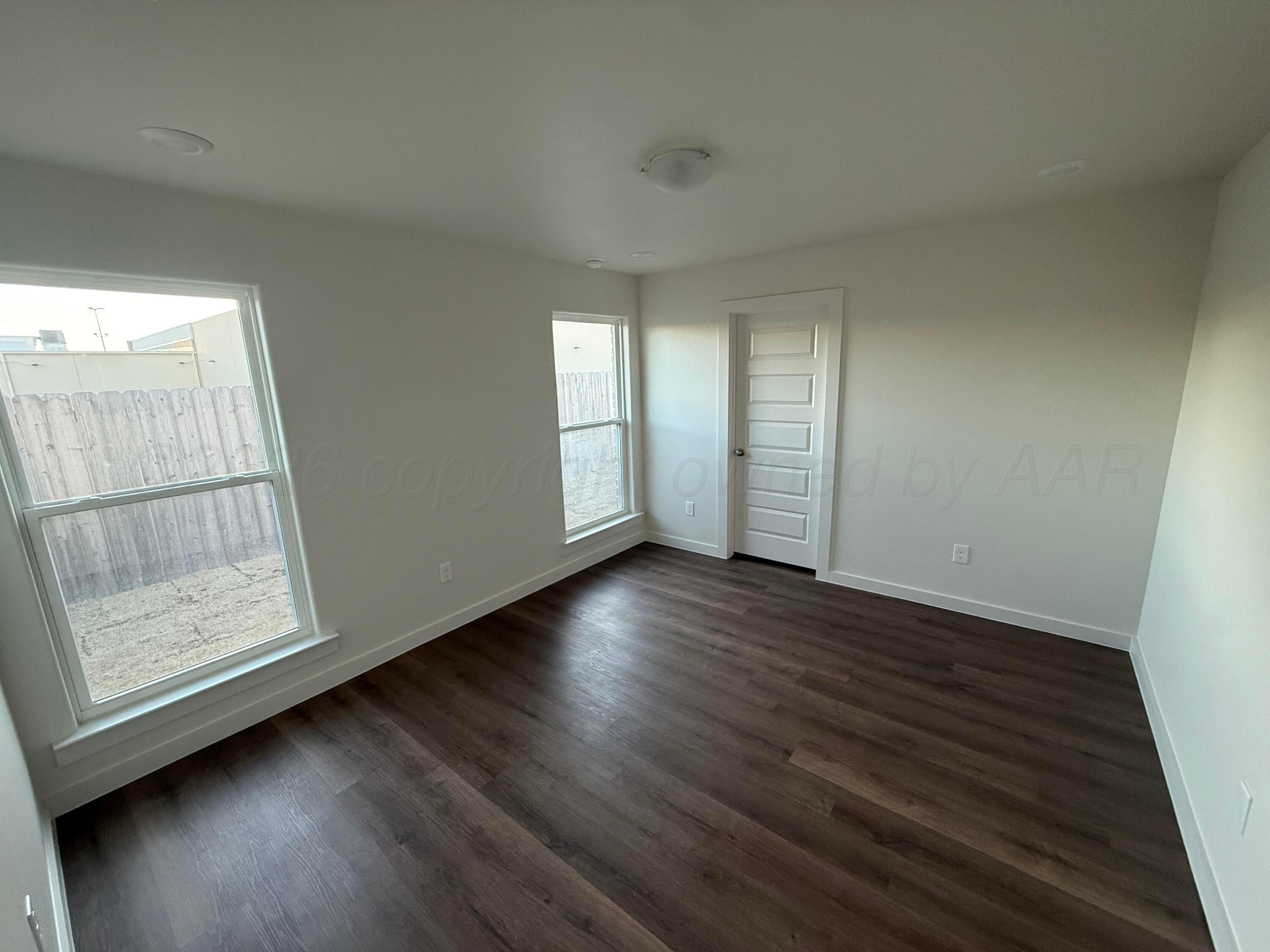 2911 Ranch House Road Amarillo, TX 79124 - Photo 16 of 18 an empty room with wooden floor and windows