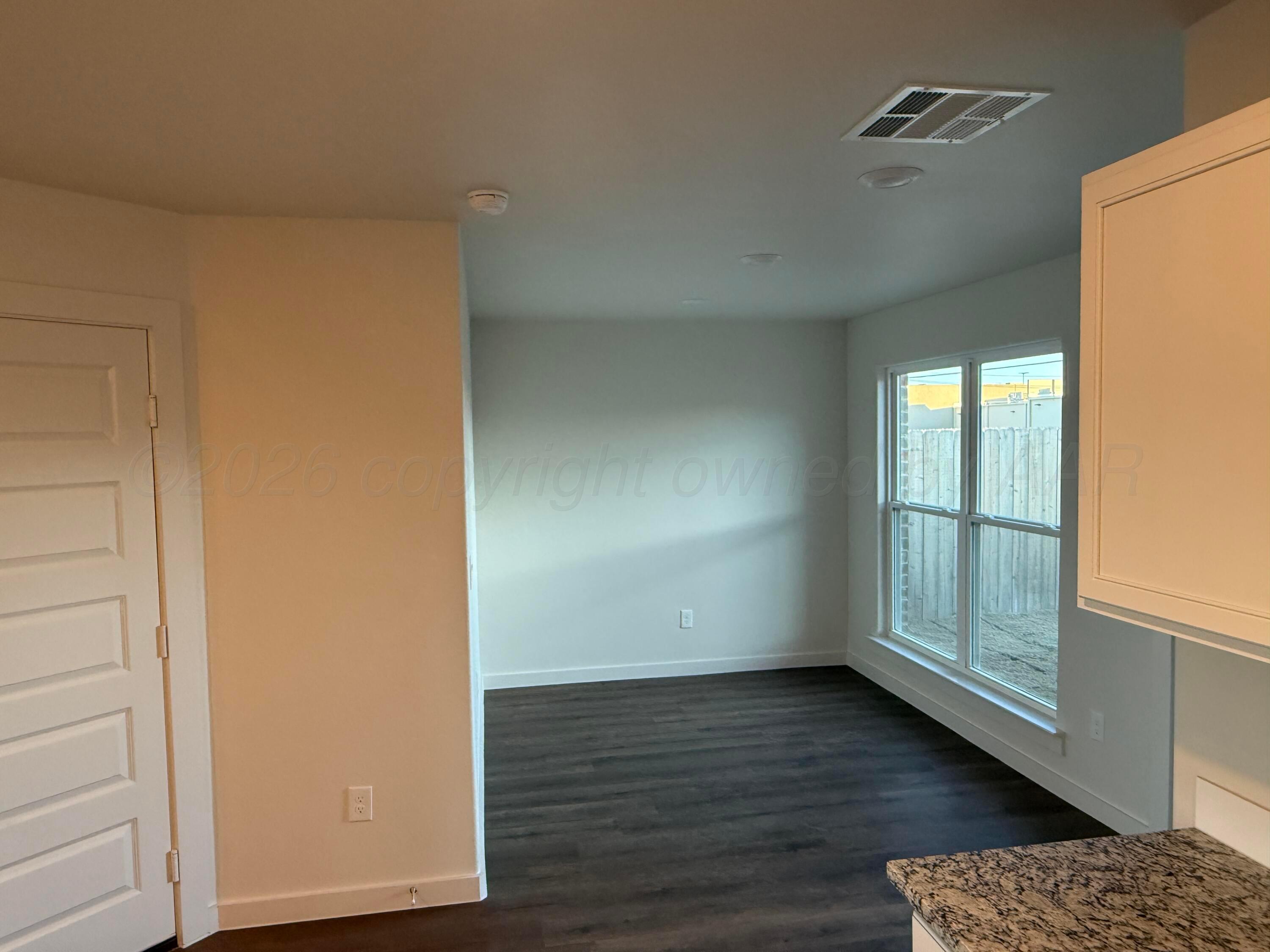 2911 Ranch House Road Amarillo, TX 79124 - Photo 3 of 18 an empty room with wooden floor and windows