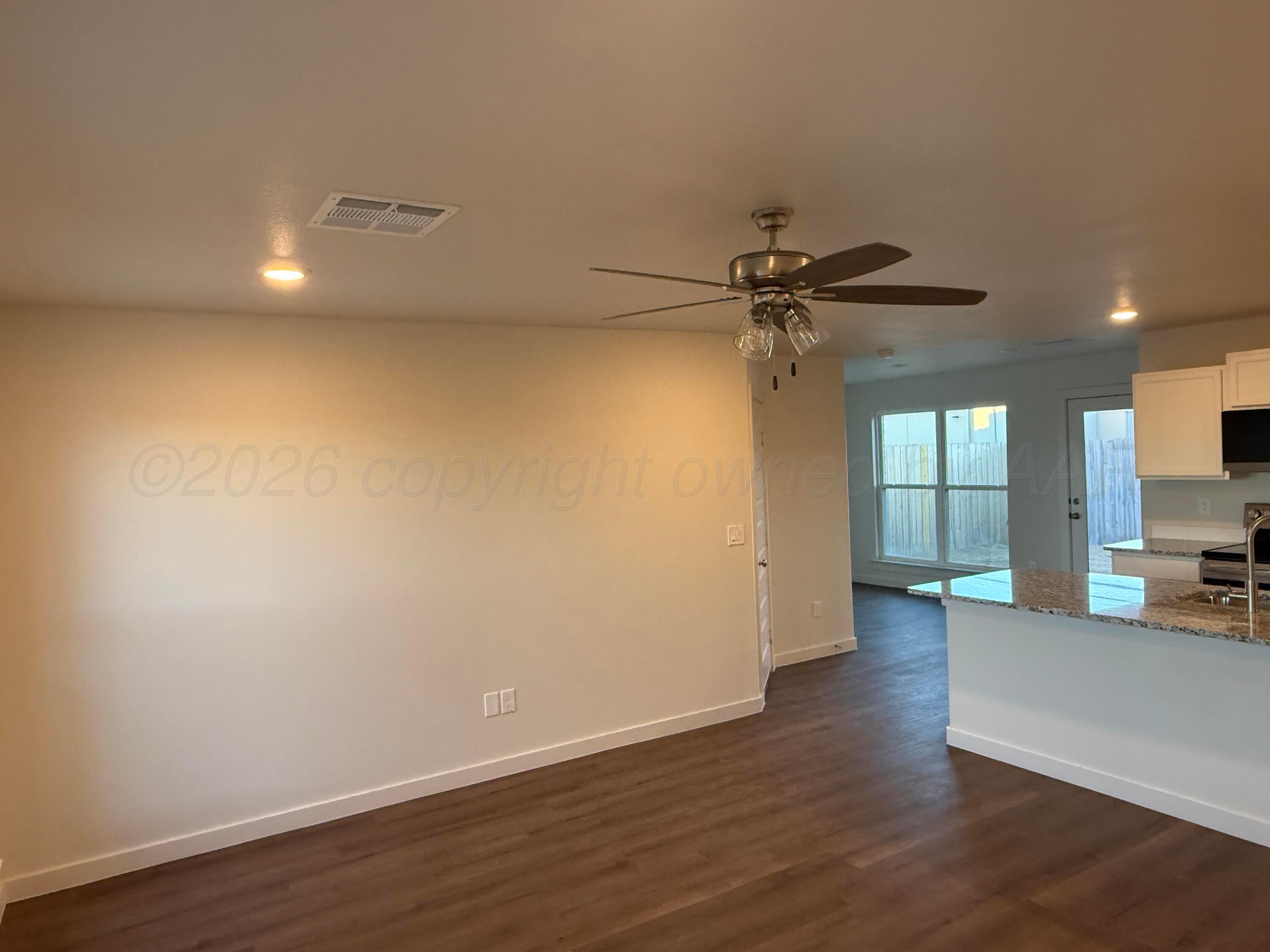 2911 Ranch House Road Amarillo, TX 79124 - Photo 5 of 18 a view of a livingroom with wooden floor and a ceiling fan