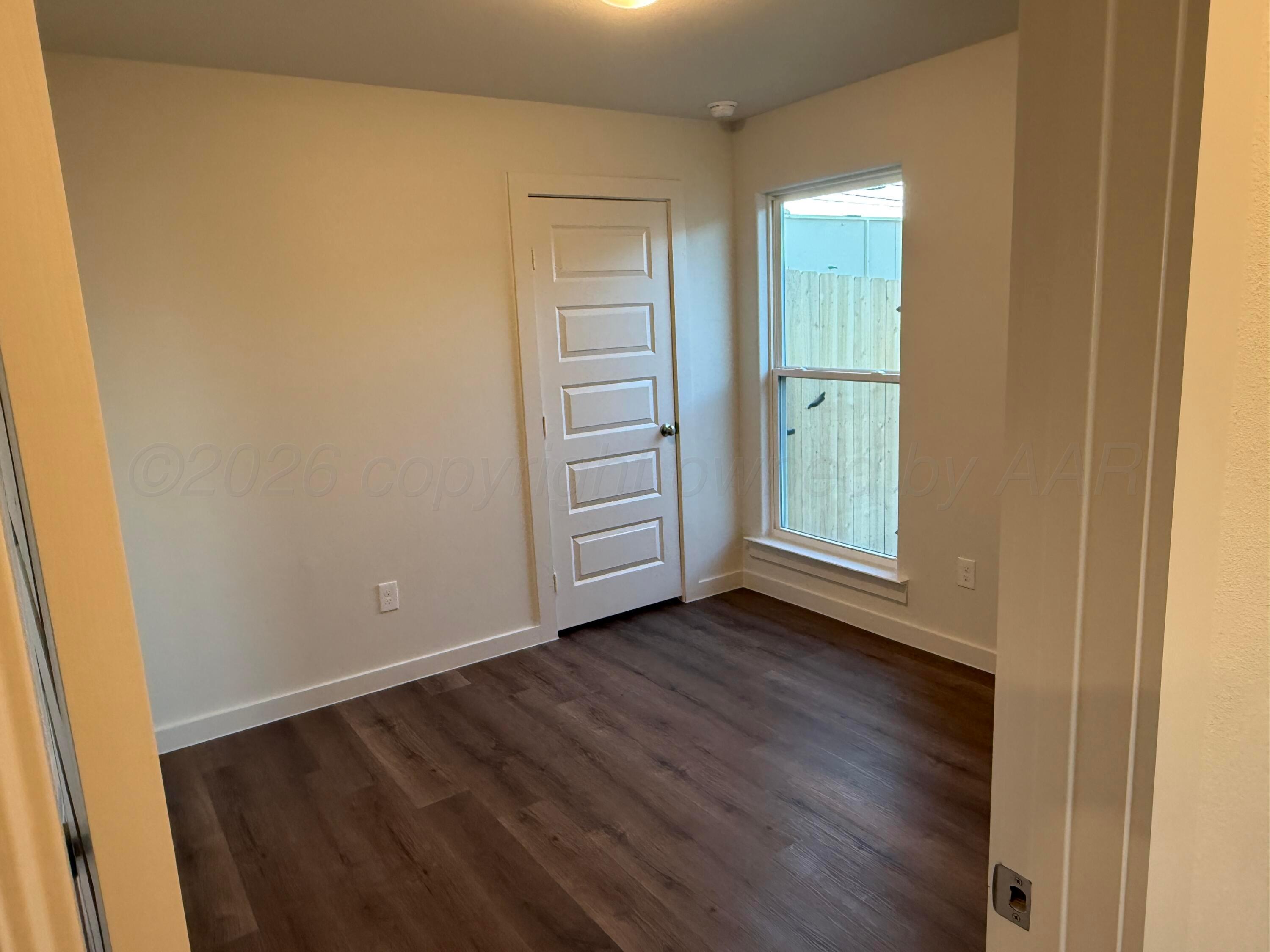 2911 Ranch House Road Amarillo, TX 79124 - Photo 6 of 18 an empty room with wooden floor closet and windows