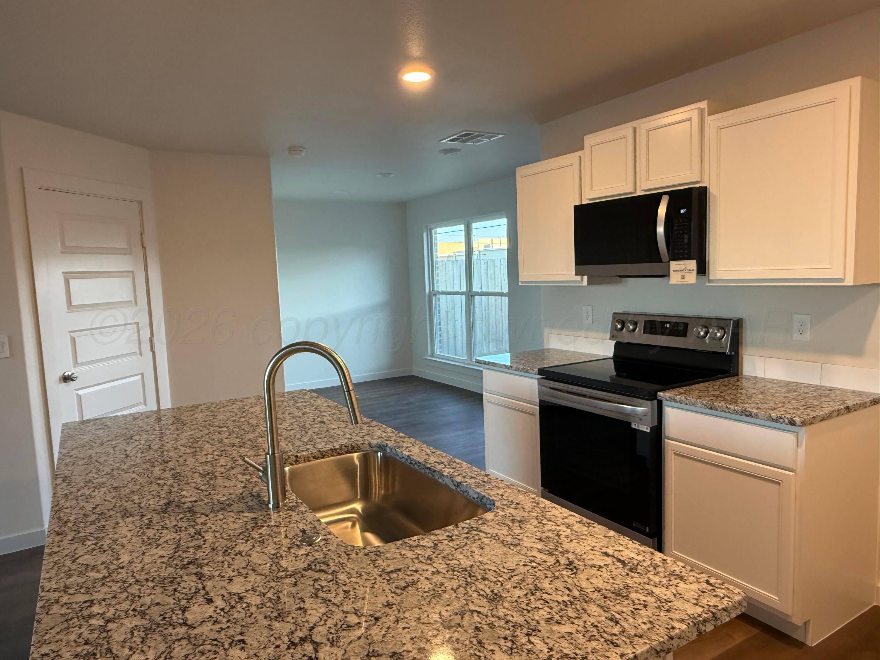 2911 Ranch House Road Amarillo, TX 79124 - Photo 7 of 18 a kitchen with a stove a sink and a microwave