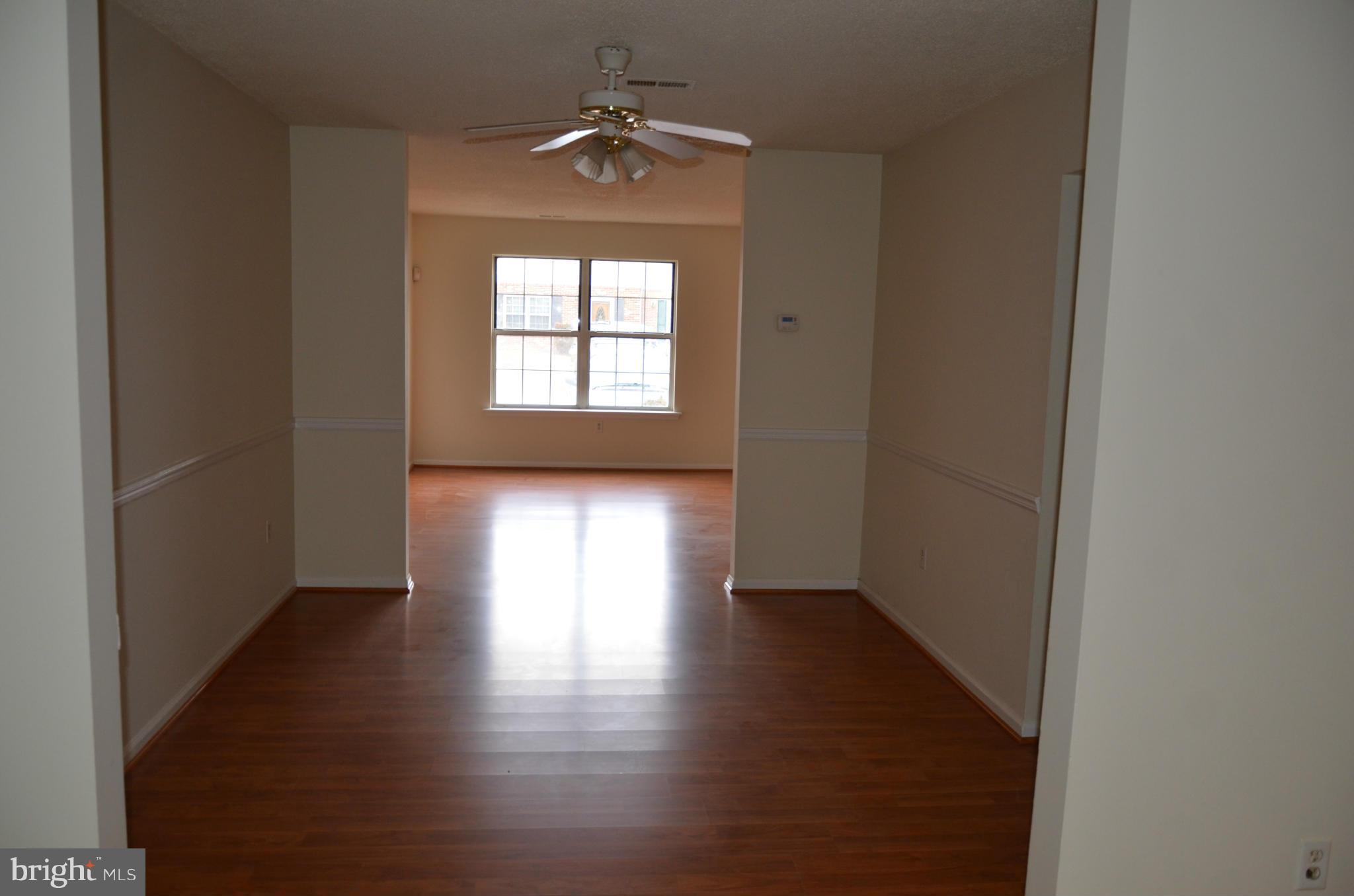 3626 Anchorage Cove Triangle, VA 22172 - Photo 6 of 11 an empty room with wooden floor chandelier and windows