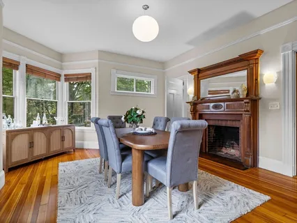 a dining room with furniture a fireplace and wooden floor